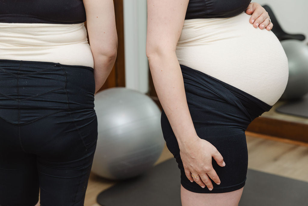 Pregnant woman with exercise balls in the background, wearing abdominal support band, tubigrip