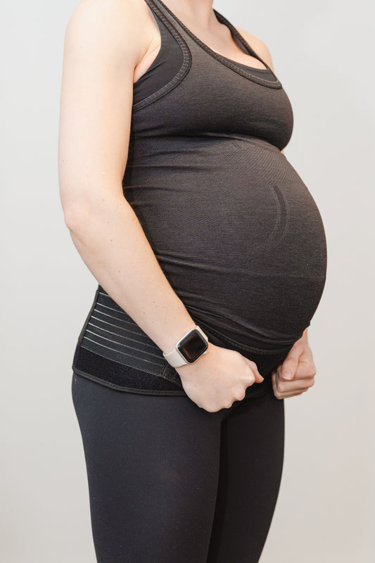 pregnant woman wearing a black outfit and a black pelvic belt