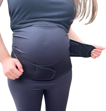 Pregnant woman putting on pregnancy pelvic belt for pelvic girdle pain