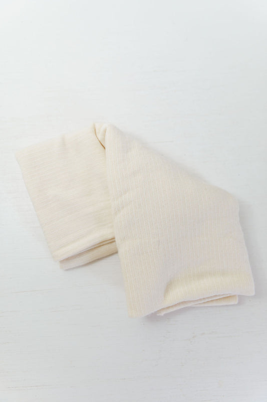 Folded beige abdominal tubi on a white background