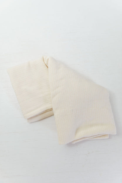 Folded beige abdominal tubi on a white background